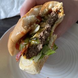 The Hot Potato - Half eaten fully loaded cheeseburger