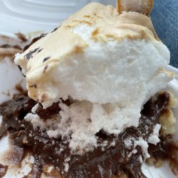 Half eaten chocolate crème pie with merengue topping.