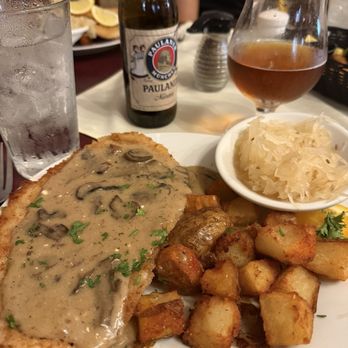 Alpine Haus Restaurant - JAGER-RAHM SCHNITZEL Pork  Schnitzel topped with mushroom and sour cream gravy, fried potatoes and sauerkraut - German Near Me - New Braunfels, Texas
