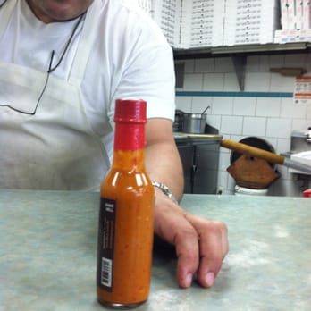 Jerusalem Pizza Falafel - a man sitting at a counter with a hot sauce in front of him - Pizza Near Me - Passaic, New Jersey Jerusalem Pizza Falafel - a man sitting at a counter with a hot sauce in front of him - Pizza Near Me - Passaic, New Jersey