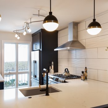 Alpha Design Build - a kitchen with white countertops and black cabinets - General Contractors Near Me - Ann Arbor, Michigan