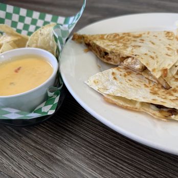 Pickles Americas Grill - Chicken quesadilla made with fried onions, jalapenos, chives, diced tomatoes, melted cheese, grilled chicken, served with chips and queso - American Near Me - Moore, Oklahoma Pickles Americas Grill - Chicken quesadilla made with fried onions, jalapenos, chives, diced tomatoes, melted cheese, grilled chicken, served with chips and queso - American Near Me - Moore, Oklahoma