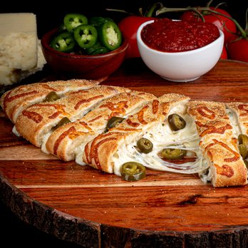 Calzone Life - a piece of pizza on a cutting board - Food Delivery Services Near Me - Windsor, California