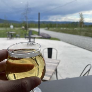 Big Mountain Ciderworks - a person holding a glass of cid - Cideries Near Me - Kalispell, Montana