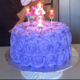 a woman blowing out candles on a cake a woman blowing out candles on a cake
