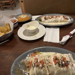 Two burrito grande's; one was shredded chicken and the other with shredded chicken, beef and shrimp with a side of beans and rice.