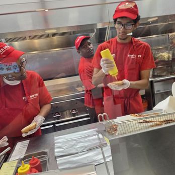 Five Guys - Employees preparing the food with the individualized order of the customers. - Burgers Near Me - Roanoke, Virginia
