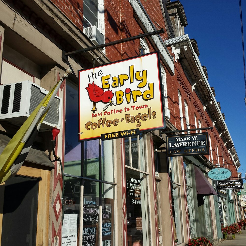 a man sitting in front of a coffee shop a man sitting in front of a coffee shop