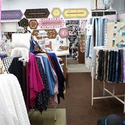 Yards of Fabric - Nice placemat samples on back wall.