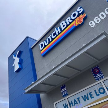 Dutch Bros Coffee - A Dutch Bros Coffee storefront features prominent signage and a pharmacy symbol on a gray building exterior. - Coffee & Tea Near Me - Albuquerque, New Mexico