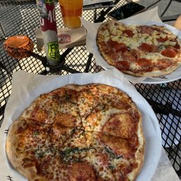 two pizzas on plates on a table two pizzas on plates on a table