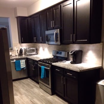 Phoenix Stone - a kitchen with black cabinets and stainless steel appliances - General Contractors Near Me - San Jacinto, California Phoenix Stone - a kitchen with black cabinets and stainless steel appliances - General Contractors Near Me - San Jacinto, California