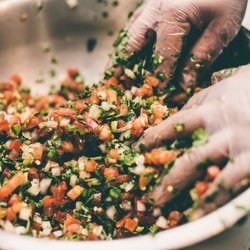Fresh pico de gallo is prepared by hand using diced tomatoes, onions, cilantro, jalapeños, and lime, showcasing Tacoria's com...