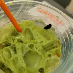  a plastic cup filled with green liquid