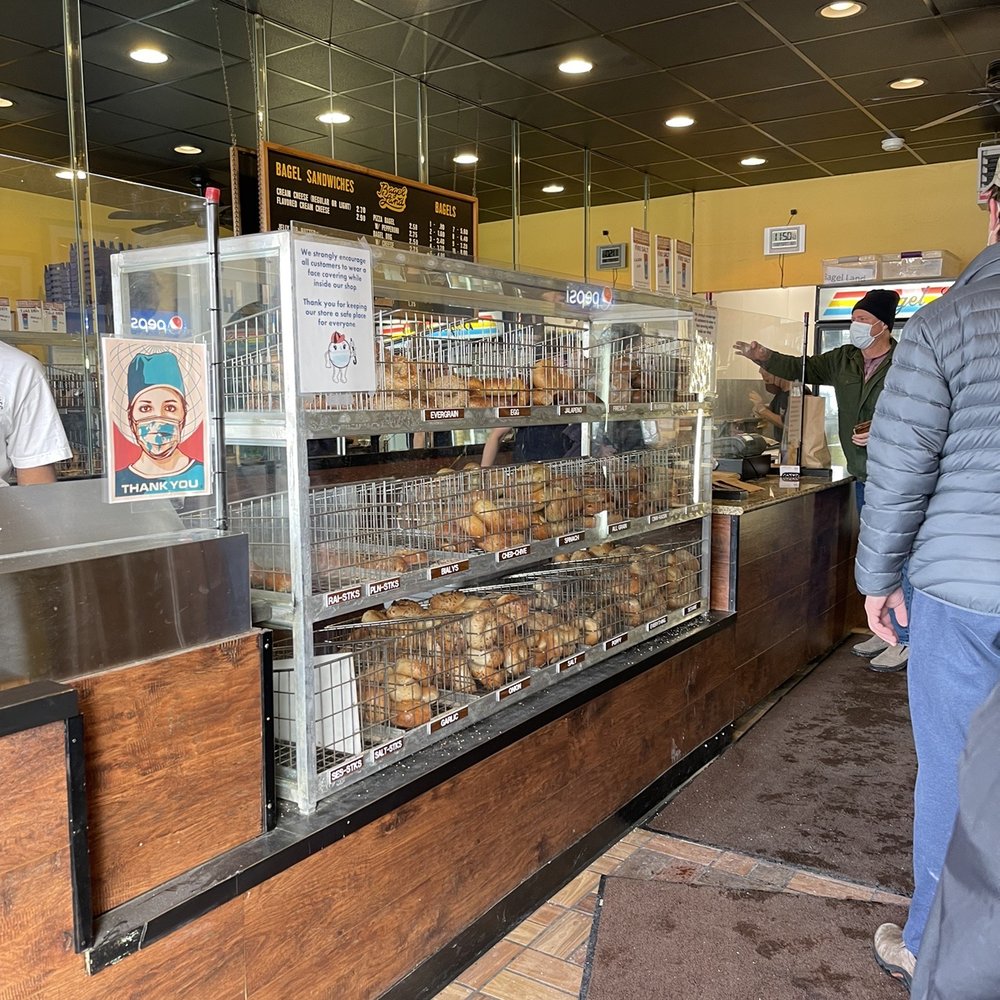 Bagel Land - a man standing in front of a bakery counter - Bagels Near Me - Rochester, New York Bagel Land - a man standing in front of a bakery counter - Bagels Near Me - Rochester, New York