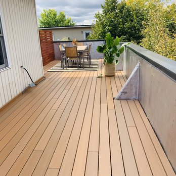 Perfect Construction - a deck with a table and chairs - General Contractors Near Me Perfect Construction - a deck with a table and chairs - General Contractors Near Me