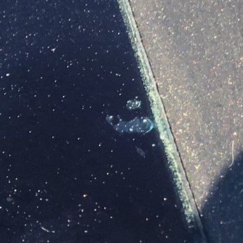 Turttle's Auto Glass - (Close up) Windshield glass defect on right side edge. This is the top of the glass. It appears to be a hole. - Auto Glass Services Near Me - Auburn, California Turttle's Auto Glass - (Close up) Windshield glass defect on right side edge. This is the top of the glass. It appears to be a hole. - Auto Glass Services Near Me - Auburn, California