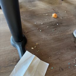 a person's foot and a paper bag on the floor