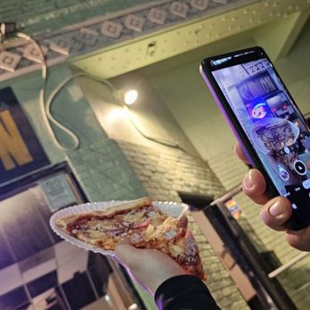 The Onion - a person taking a picture of a slice of pizza - Pizza Near Me - Austin, Texas The Onion - a person taking a picture of a slice of pizza - Pizza Near Me - Austin, Texas