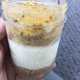 a hand holding a cup of dessert a hand holding a cup of dessert