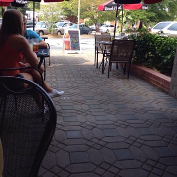 Converse Deli - a woman sitting at a table under umbrellas - Delis Near Me - Spartanburg, South Carolina
