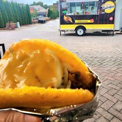 Stuffed chicken and beef arepa with shredded cheese and Nacho cheese.
