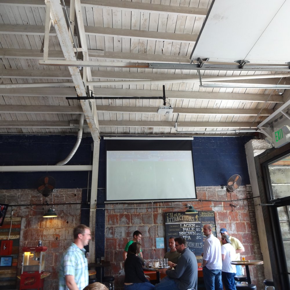 Hi-Wire Brewing - Shuffle board alongside the wall and projector TV. - Breweries Near Me - Asheville, North Carolina Hi-Wire Brewing - Shuffle board alongside the wall and projector TV. - Breweries Near Me - Asheville, North Carolina