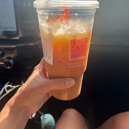 a person holding a drink in a car