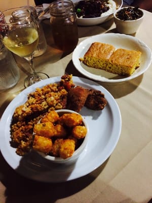 Photo of The Quarters - Auburn, WA, US. Jambalaya with a piece of chicken and a side (I chose tater tots), corn bread, oxtail over a bed of grits and collard greens
