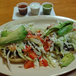 Sopes de carne asada, all dressed up, crema on the side. Salsas are excellent, the Verde was crazy good.