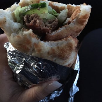 Food Village - a hand holding a sandwich wrapped in aluminum foil - Indian Near Me - Whitby, Ontario Food Village - a hand holding a sandwich wrapped in aluminum foil - Indian Near Me - Whitby, Ontario