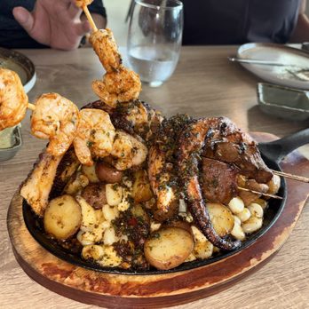 Aromas del Peru - Anticuchos. Beef Heart, Potatoes, Cheese, Corn, Octopus, and Shrimp with Seasonings and Chimichurri. - Peruvian Near Me - Pompano Beach, Florida Aromas del Peru - Anticuchos. Beef Heart, Potatoes, Cheese, Corn, Octopus, and Shrimp with Seasonings and Chimichurri. - Peruvian Near Me - Pompano Beach, Florida