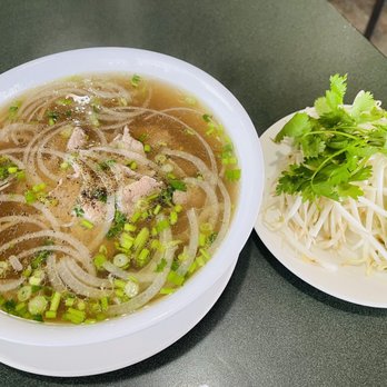 Saigon Bistro - P2 Beef noodle soup.  Inside is onions beef noodles and scallions, on the side is cilantro, lime, spicy pepper, and bean sprouts. - Vietnamese Near Me - Fayetteville, North Carolina