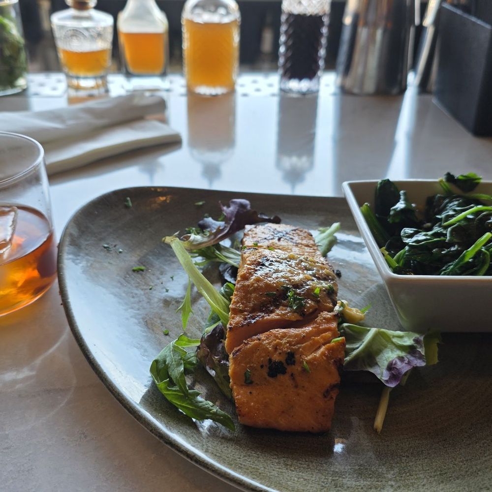 Grilled salmon and sautéed spinach with an old fashioned. Grilled salmon and sautéed spinach with an old fashioned.