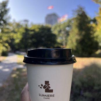 Lumiere Cafe - a hand holding a coffee cup - Coffee & Tea Near Me - Vancouver, British Columbia