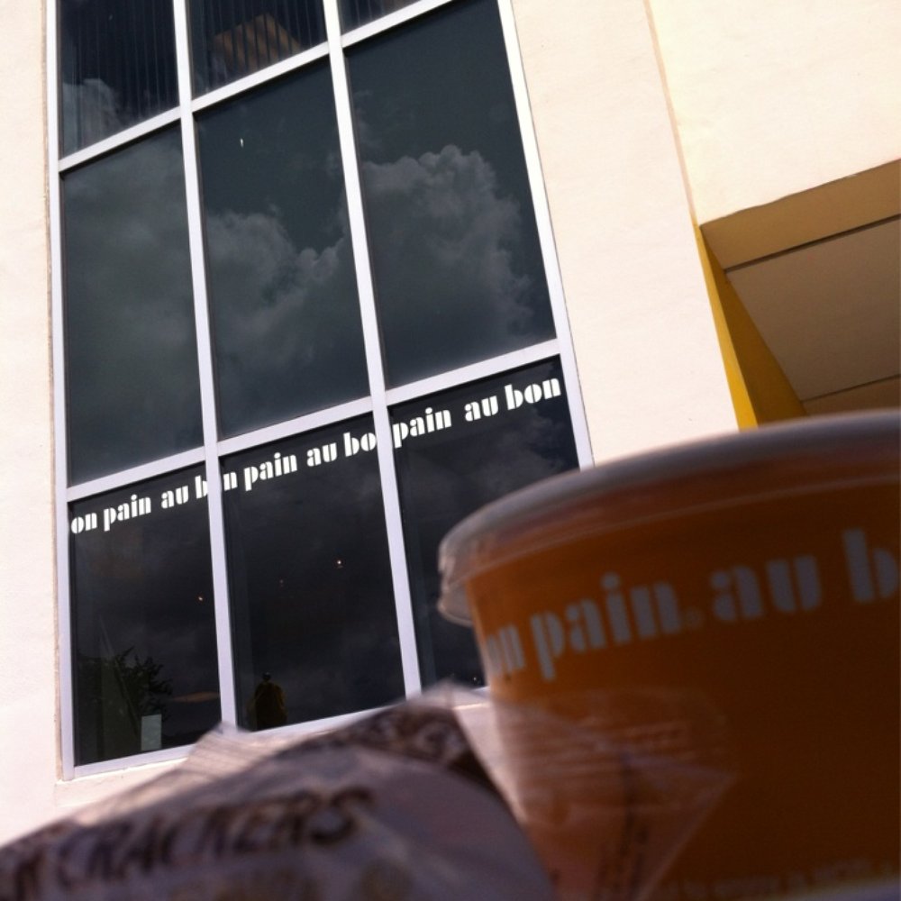 a cup of coffee on a table in front of a building a cup of coffee on a table in front of a building