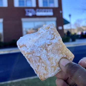 PJ's Coffee - a hand holding a sugared pastry - Coffee & Tea Near Me - Bowie, Maryland