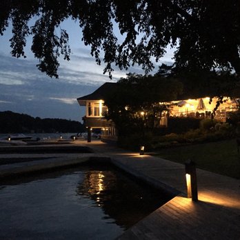 Water's Edge Restaurant - a man standing on a dock at night - Seafood Near Me - Port Carling, Ontario Water's Edge Restaurant - a man standing on a dock at night - Seafood Near Me - Port Carling, Ontario