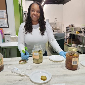 Aliska's Amazing Pickles - Aliska holding her green tongs - Specialty Food Near Me - St. Louis, Missouri Aliska's Amazing Pickles - Aliska holding her green tongs - Specialty Food Near Me - St. Louis, Missouri