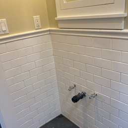Wall and floor tile repair in small bathroom.