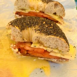 Poppyseed bagel, with scallion cream cheese, tomato, cucumber, and bacon.