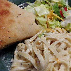 Little Italy Pizzeria - Fettuccine Alfredo with a bite taken out of my bread. lol