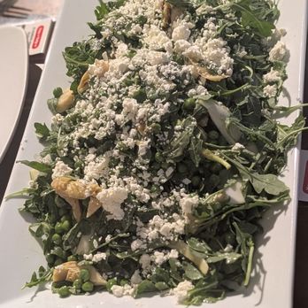 Vineapple - A rectangular white plate holds a salad made of mixed greens, artichoke hearts, peas, and crumbled cheese, garnished with a lemon wedge. - Italian Near Me - Brooklyn, New York