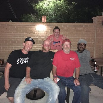 TommyJack's Pub - a group of men sitting around a fire pit - Pubs Near Me - Sioux Falls, South Dakota