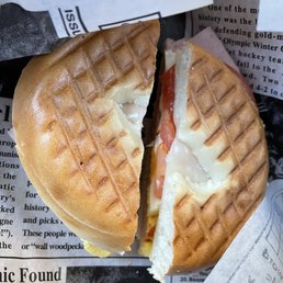 a half eaten sandwich on a newspaper