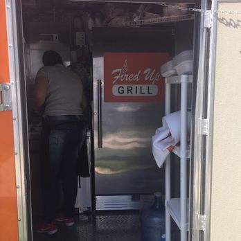 Fired Up Grill - a woman standing in the doorway of a food truck - Food Trucks Near Me Fired Up Grill - a woman standing in the doorway of a food truck - Food Trucks Near Me