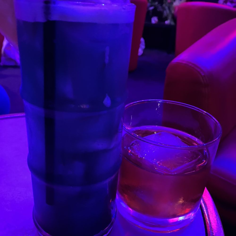 a drink and a glass on a table a drink and a glass on a table