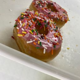  a pink frosted donut with sprinkles