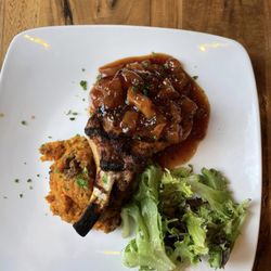 Blueberry Pines Golf Club - Peach Glazed Pork Chop! 10oz French style pork chop topped with sweet & spicy peach glaze. Served over sweet potato-pecan soufflé.