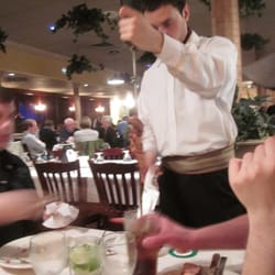 Gauchos Brazilian Steak House - A Gaucho carving some meat for the table. (notice card, green side up, on table.)